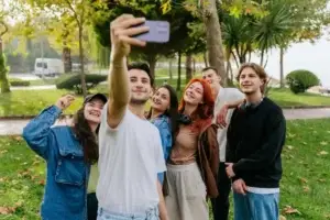 Παρέα έξι νέων παίρνει χαρούμενη selfie σε πάρκο, επιδεικνύοντας καθαρό υγιές δέρμα και αυτοπεποίθηση μετά από επιτυχημένη ομοιοπαθητική θεραπεία για ακμή στην Αθήνα