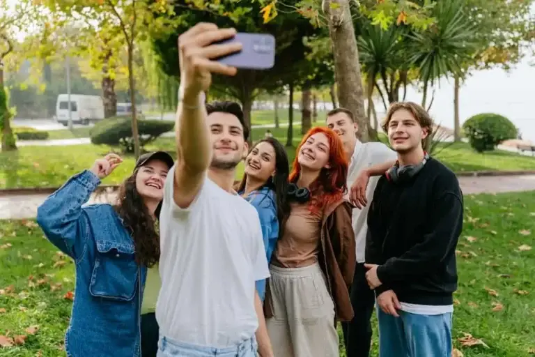 Παρέα έξι νέων παίρνει χαρούμενη selfie σε πάρκο, επιδεικνύοντας καθαρό υγιές δέρμα και αυτοπεποίθηση μετά από επιτυχημένη ομοιοπαθητική θεραπεία για ακμή στην Αθήνα