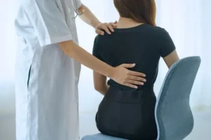 Ομοιοπαθητικός ιατρός εξετάζει ασθενή με πόνο στη μέση και ισχιαλγία στο ιατρείο του στην Αθήνα.