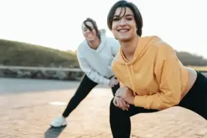 Γυναίκες γεμάτες ενέργεια κάνουν γυμναστική σε εξωτερικό χώρο, συμβολίζοντας την πλήρη ανάκαμψη από Long COVID και χρόνια κόπωση με τη βοήθεια της ομοιοπαθητικής.