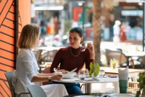 Γυναίκες απολαμβάνουν το γεύμα τους χωρίς πόνο - διαχείριση στοματικών αφθών στη νόσο Αδαμαντιάδη-Behçet με ομοιοπαθητική