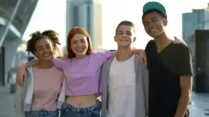 Μια παρέα εφήβων που χαμογελούν, συμβολίζοντας τη συναισθηματική ισορροπία μέσω ομοιοπαθητικής υποστήριξης.