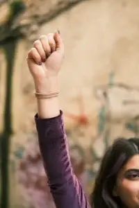 Γυναίκα σηκώνει τη γροθιά της σε ένδειξη διαμαρτυρίας – η ιδιοσυγκρασία Causticum χαρακτηρίζεται από βαθύ αίσθημα αδικίας