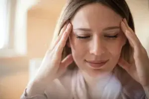 Γυναίκα με ημικρανία κρατάει τον κρόταφο - η σύνδεση ημικρανίας και άγχους