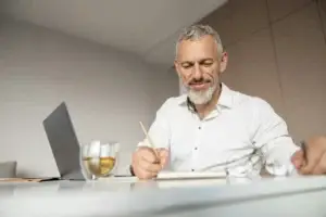 Εργαζόμενος άνδρας σε γραφείο με ρόφημα — νεύρωση στομάχου και στρες στην καθημερινότητα